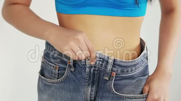 女人展示了她的减肥穿着牛仔裤视频的预览图
