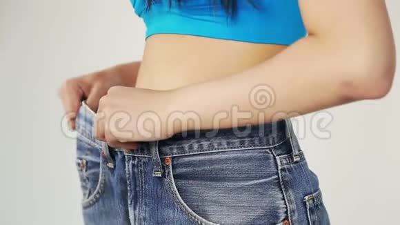 女人展示了她的减肥和穿牛仔裤视频的预览图