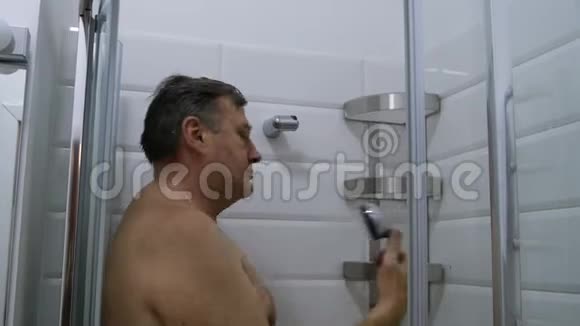 成年人白种人男人洗澡假装做一个自拍与淋浴头视频的预览图