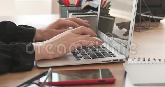 女人在办公室笔记本电脑上打字视频的预览图