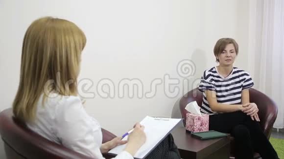 女性心理学家在心理治疗期间做笔记伤心的女孩视频的预览图