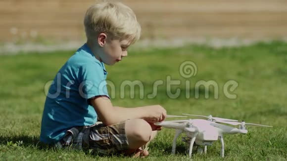 孩子们在绿草地上组装现代无人机安装螺旋桨视频的预览图