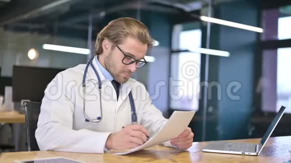 医生在诊所阅读医疗文件视频的预览图