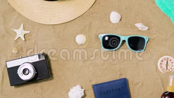 沙滩沙上的照相机护照太阳镜和帽子视频的预览图
