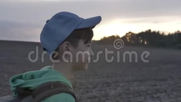 带背包的男孩在日落时在户外散步旅行理念视频的预览图