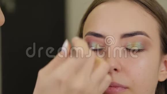 专业的化妆师给美容院的客户蒙上了眼影视频的预览图
