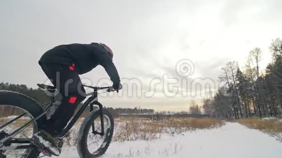专业的极限运动员骑自行车在户外骑胖自行车骑自行车在冬天的雪林里男人是审判视频的预览图