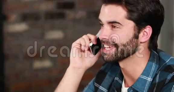 微笑的时髦男人在电话里讨论视频的预览图