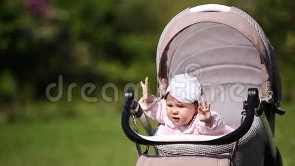 小可爱的女婴坐在婴儿车里视频的预览图