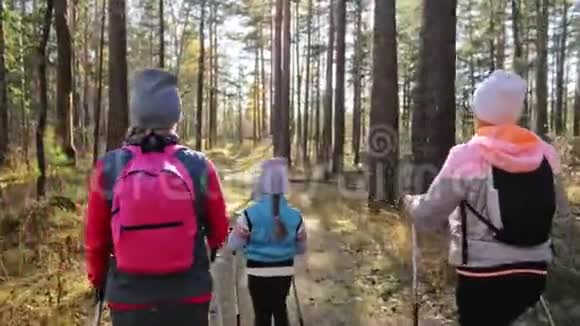 女人在大自然中行走北欧女孩和孩子使用跋涉棒和北欧杆背包家庭旅行视频的预览图