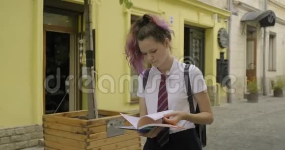 漂亮的学生少年女孩带着学校笔记本视频的预览图