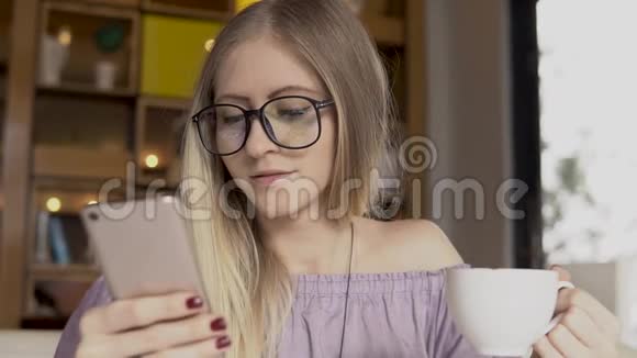 咖啡时间女性在喝咖啡时使用智能手机视频的预览图