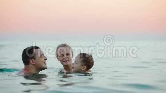 年轻父母带着儿子在海里洗澡视频的预览图