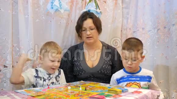 孩子们和家人在桌上玩棋盘游戏视频的预览图