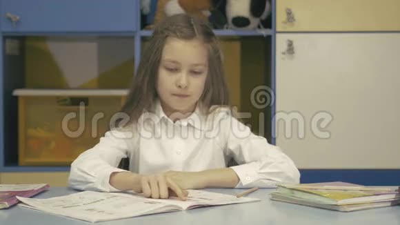 可爱的小女孩在图书馆学习做作业和微笑视频的预览图