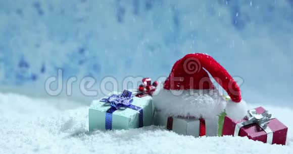 圣诞老人帽子和礼物在雪地里视频的预览图