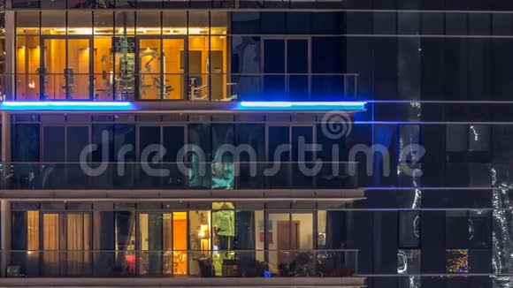 在多层现代玻璃和金属住宅建筑的发光窗口在夜间时间推移视频的预览图