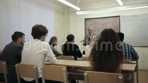 一群学生在教室里听着老师讲课视频的预览图