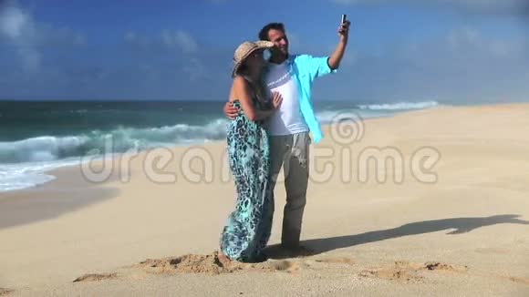 年轻的微笑情侣在沙滩上自拍视频的预览图