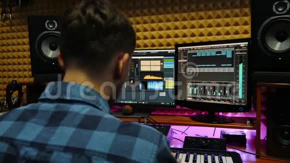 音乐家音响工程师工作在录音室与显示器和均衡器混合齿轮在屏幕上编剧混编和视频的预览图