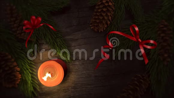 木质背景上的动画特写圣诞蜡烛和绿色树枝视频的预览图