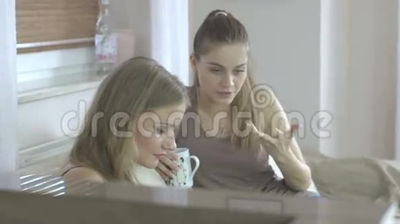 两个美女坐在沙发上用平板电脑微笑着视频的预览图