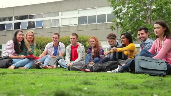 快乐的学生坐在草地上聊天视频的预览图