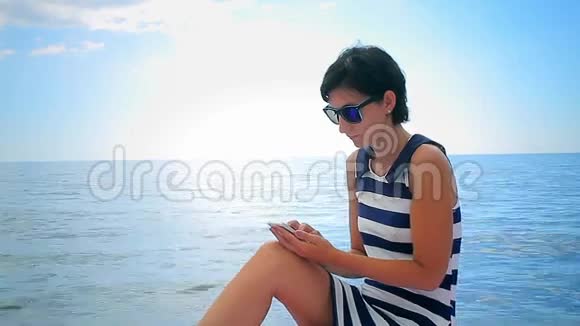 一个年轻女子在海上使用手机视频的预览图