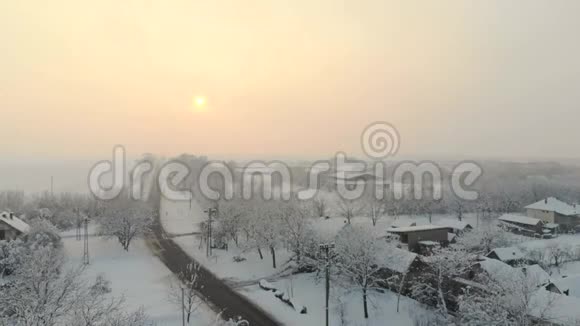 无人机4K空中镜头村庄在平原覆盖着雪白色多云的冬季天气视频的预览图