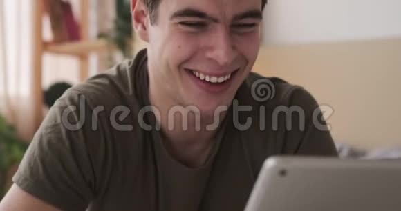 快乐的男人在家里使用数码平板电脑视频的预览图