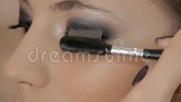 专业化妆师将化妆应用于美丽的模特彩色眼睛视频的预览图