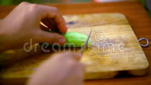 女性手在木板上切黄瓜视频的预览图