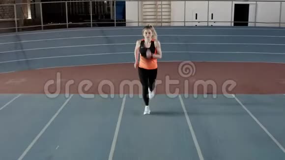 性感金发女人在室内体育场奔跑视频的预览图