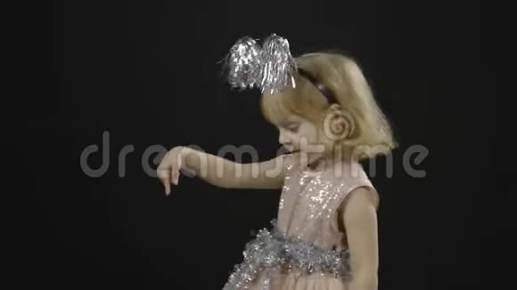 快乐美丽的小女婴穿着光滑的裙子圣诞节做鬼脸视频的预览图