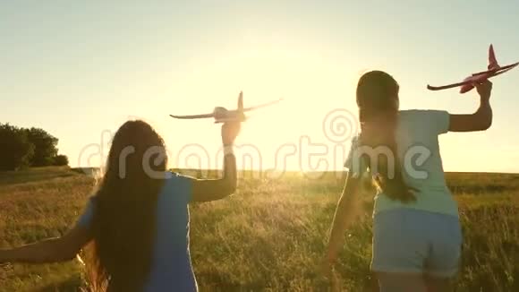 孩子们在飞机上玩耍的剪影飞行的梦想快乐的童年概念两个女孩玩玩具飞机视频的预览图