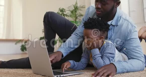 父亲和儿子在家里一起使用技术视频的预览图