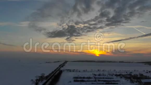 无人机4K空中镜头村庄在平原覆盖着雪白色多云的冬季天气视频的预览图