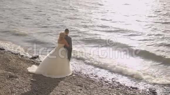 新婚夫妇一起在海边可爱的新郎和新娘慢动作视频的预览图