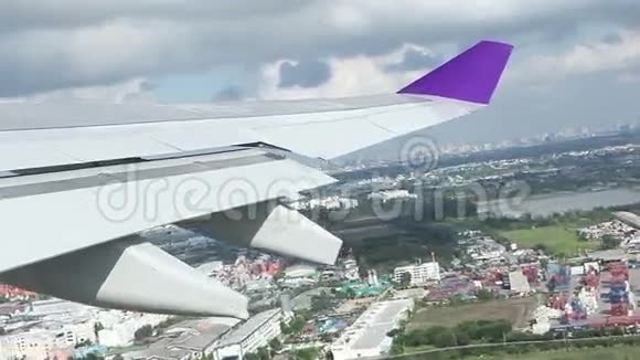 飞机在城镇或城市上空飞行的机翼从飞机的窗户射出视频的预览图
