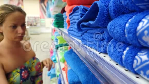 年轻女孩选择浴巾纺织服装店超市4K慢动作视频的预览图