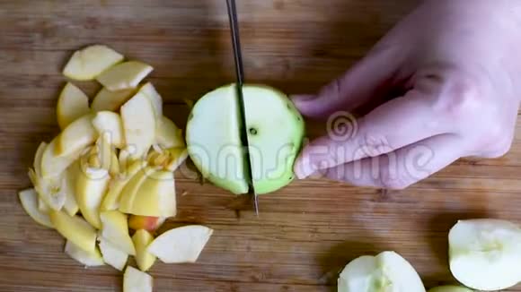把苹果切成薄片用刀子在木板上切成两半视频的预览图