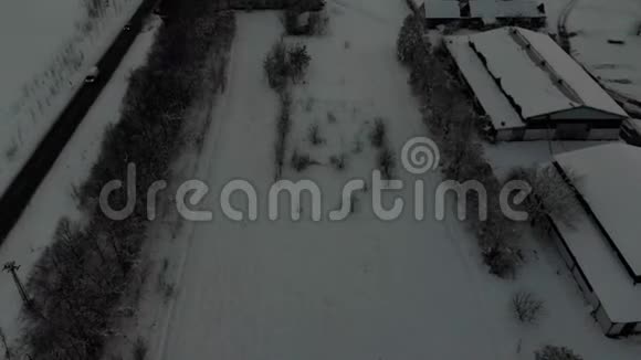 无人机4K空中镜头村庄在平原覆盖着雪白色多云的冬季天气视频的预览图