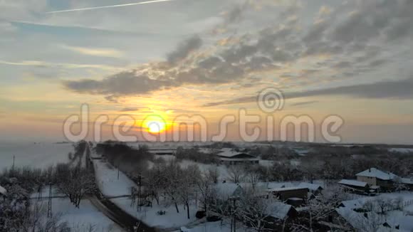 无人机4K空中镜头村庄在平原覆盖着雪白色多云的冬季天气视频的预览图