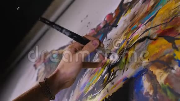 艺术家设计师在墙上画一只鹰工匠装饰师用丙烯酸油彩画一幅画近距离黑暗视频的预览图