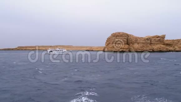 游船与游客在波涛汹涌的海面上的岩石背景下航行埃及视频的预览图