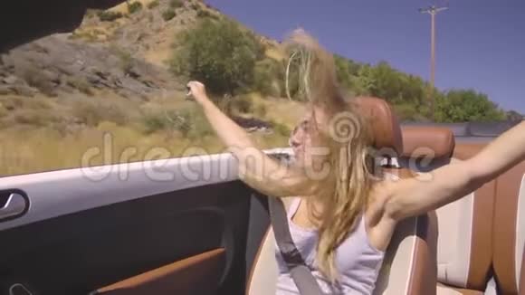 女性驾驶可兑换汽车视频的预览图