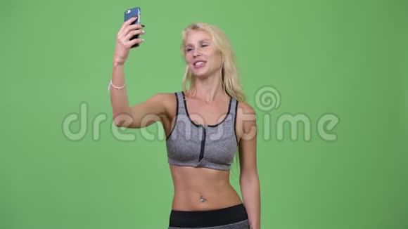 年轻漂亮的女人带着手机去健身房视频的预览图