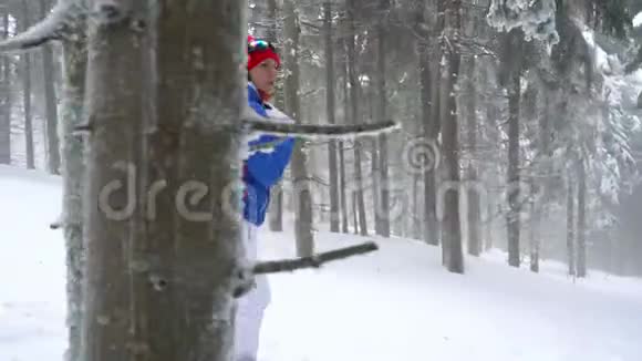 孤独的旅游女孩走在冬天白雪覆盖的针叶林在山上霜冻天气视频的预览图