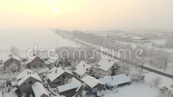 无人机4K空中镜头村庄在平原覆盖着雪白色多云的冬季天气视频的预览图