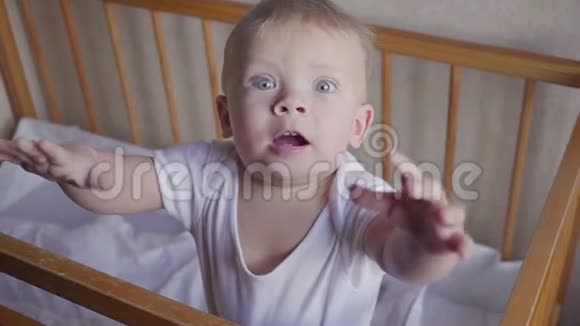 婴儿床上的孩子环顾四周说话跳跃和微笑视频的预览图